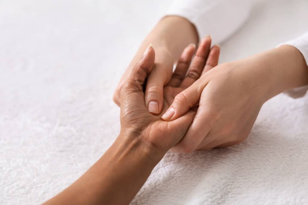 Bodyworker using deep tissue massage on hand and wrist to treat carpal tunnel pain.