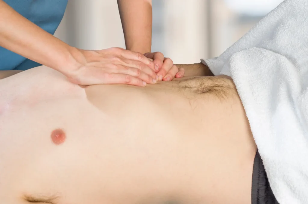 Therapist performing bodywork on a client’s chest, a technique that can help relieve costochondritis pain.