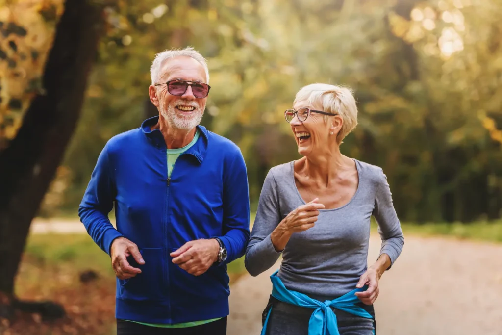 A happy senior couple jogging outdoors, enjoying an active and healthy lifestyle.