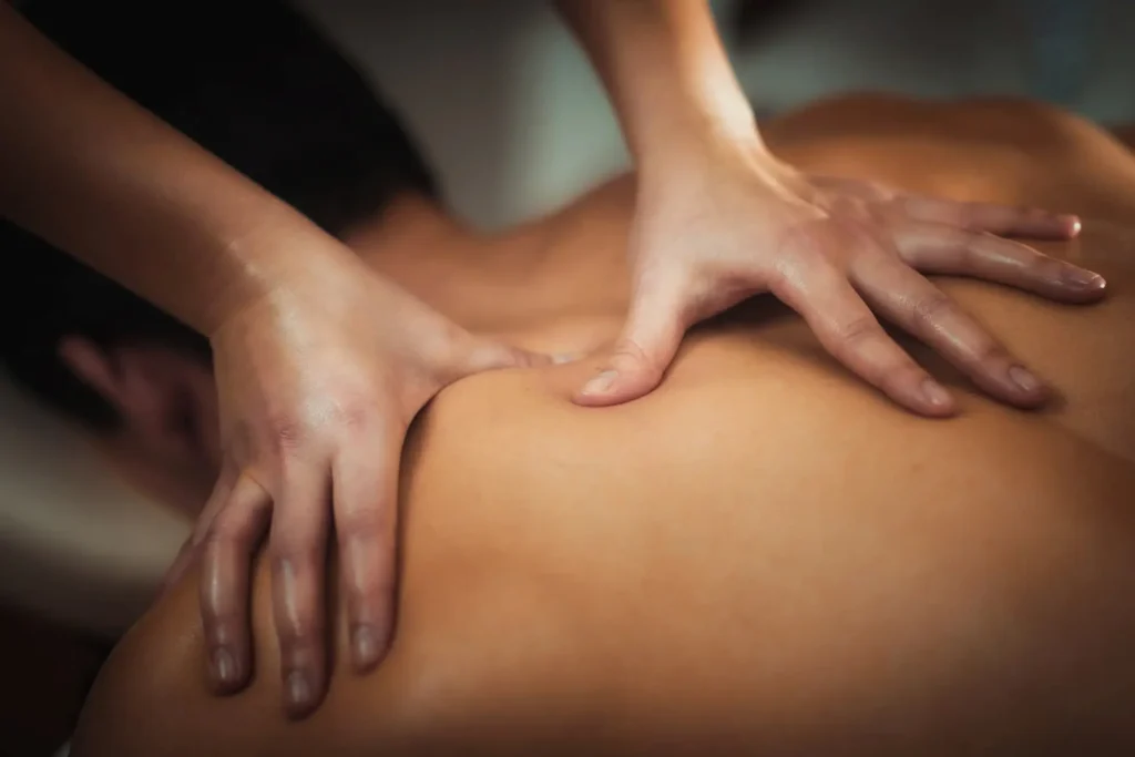 Massage therapist applying bodywork techniques to the shoulder area to relieve rotator cuff pain and tension.
