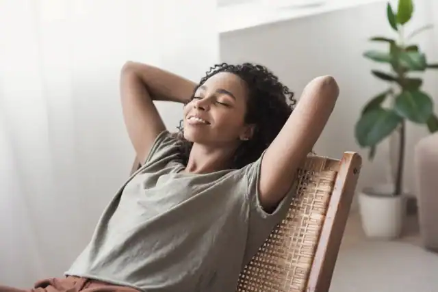 Woman relaxing peacefully after a Reiki session, feeling calm and refreshed.
